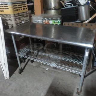 Stainless steel table with Metro under shelf on casters, 49.5x24x36 inches, used condition, ideal for industrial use.