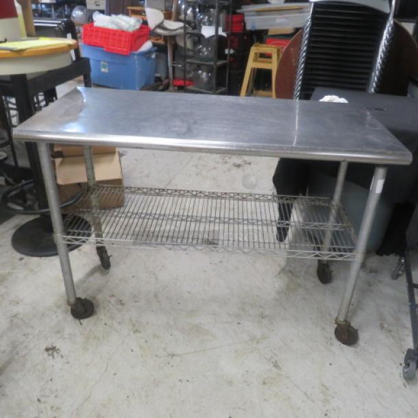 Stainless steel table, 49.5x24x36 inches, with Metro undershelf on casters. Used condition, suitable for workshops or kitchens.