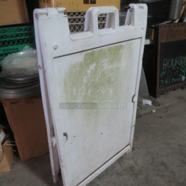 One Signcade sidewalk sign in used condition, white with noticeable wear and discoloration, featuring a handle for easy transport.