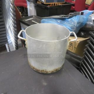 10x9.5 inch aluminum stock pot with dual handles, showing signs of wear and tarnish at the base.