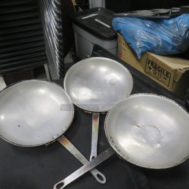 Set of three 10.5-inch sauté pans with metal handles, showing signs of wear and patina. Ideal for collectors or chefs.
