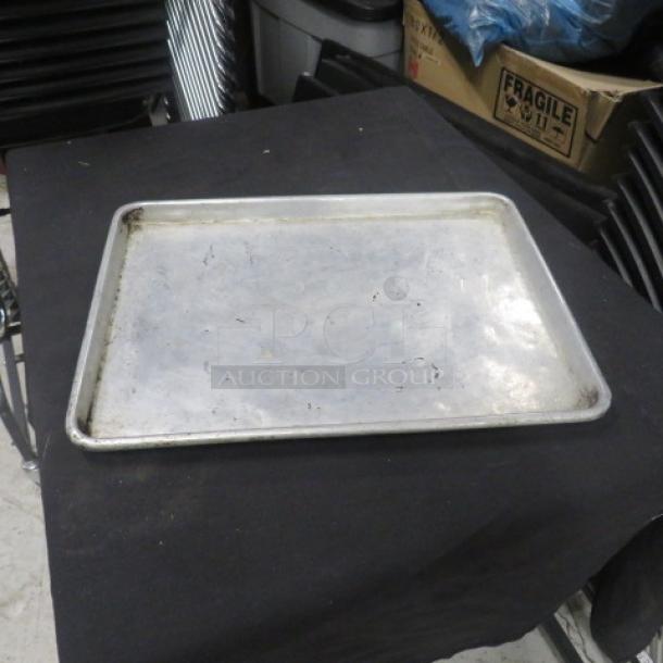 1/2 Size Sheet Pan, metal, used condition with surface scratches. Ideal for baking. No visible markings or labels.