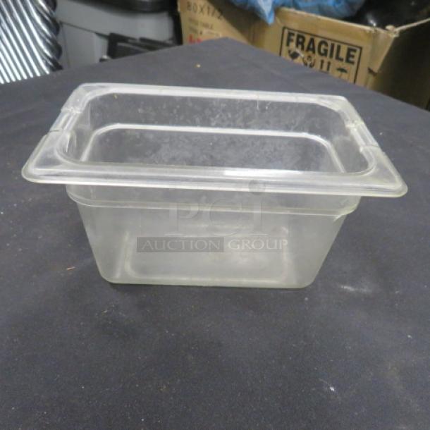 1/9 size, 4-inch deep clear food storage container, used condition. Ideal for commercial kitchens. No visible labels or markings.