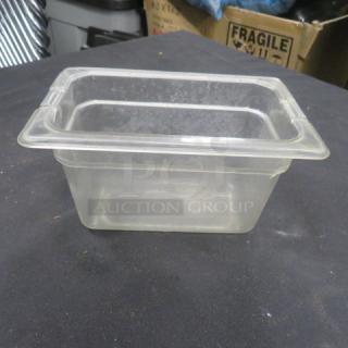 1/9 size, 4-inch deep clear food storage container, used condition. Ideal for commercial kitchens. No visible labels or markings.