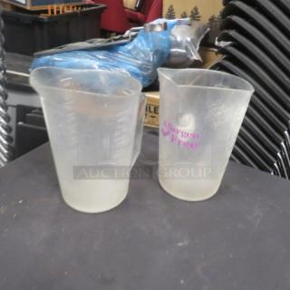 Pair of 4-quart measuring cups, clear plastic, labeled "Allergen Free." Visible wear, used condition.