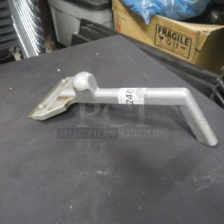 Metal griddle scraper with angled handle, light wear, auction tag number 240 visible on handle.