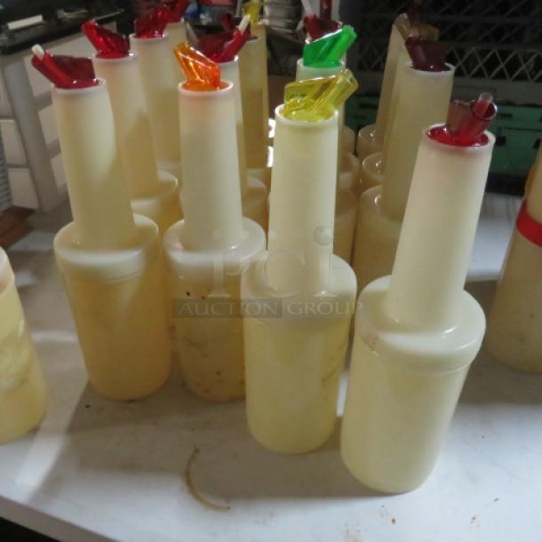 Store N Pour bottles with colorful spouts, used condition, suitable for bar and kitchen use, grouped on a table.