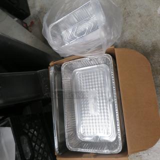 One lot of full-size and 1/3 size foil containers, stacked in a box and plastic bag. Ideal for catering or food service.