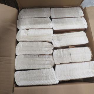 One opened case containing stacks of Tork dinner napkins, neatly packed, showcasing their unblemished, white condition.