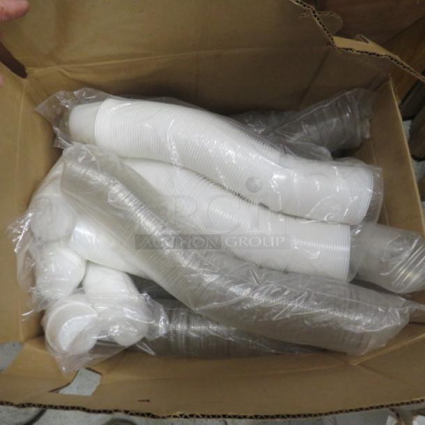 Box of white portion cups in plastic sleeves, new condition, ideal for catering or restaurant use.