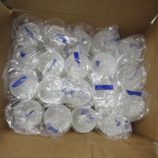Box of individually wrapped portion cups stacked neatly. Clear plastic cups with blue seals, indicating freshness.