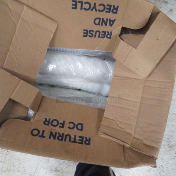 Open cardboard box containing white disposable cups, partially sealed in plastic. Box marked "Reuse and Recycle."