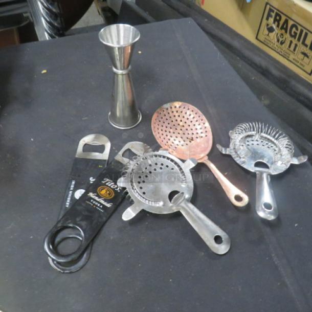 Assorted barware set including jigger, bottle openers, and strainers, featuring stainless steel and copper finishes, in good condition.