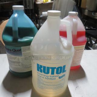 Three gallon-sized containers of assorted cleaner, including Kutol Foaming Instant Hand Sanitizer, with visible product labels.