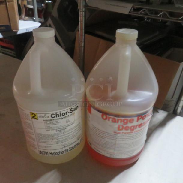 Two gallon containers of cleaner: Chlor-San Hypochlorite Solution and Orange Power Degreaser, both with visible labels.