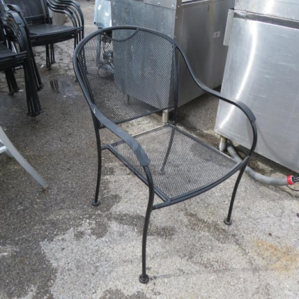 Black metal patio chair with mesh seat and back, showing light wear. Durable construction, suitable for outdoor use.
