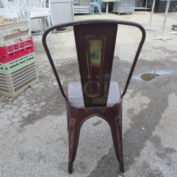 Industrial metal chair with a distressed finish, suitable for indoor/outdoor use. Features a vintage look and sturdy backrest.