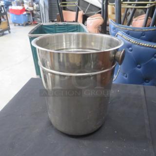 Stainless steel wine/champagne bucket, cylindrical with handle, reflective finish, excellent condition, suitable for elegant dining.