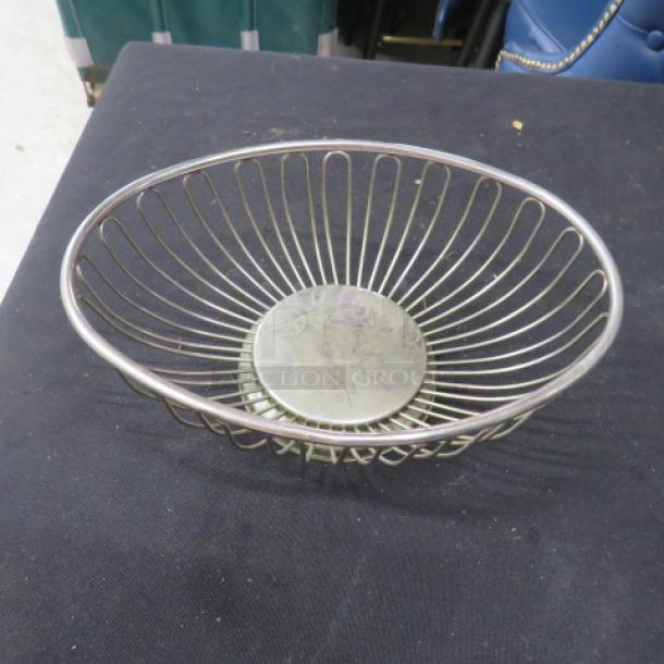One of 27 stainless steel basket servers, wire design, round base, used condition, ideal for restaurant use.