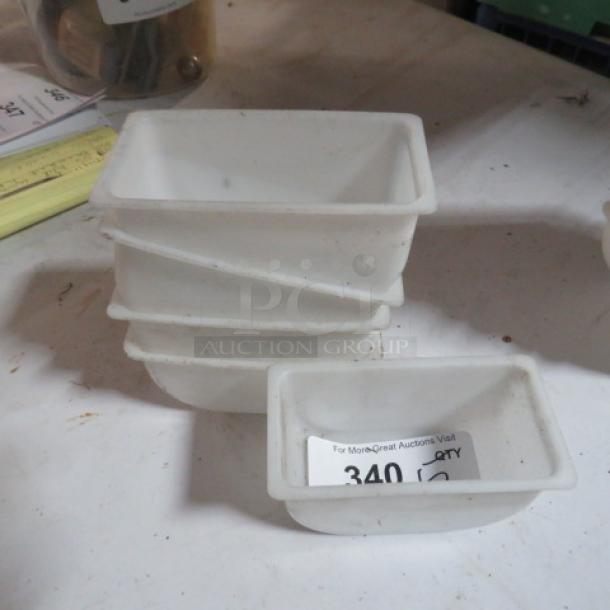 White plastic bar center holders, stack of five, used condition, with one showing auction label marked "340 QTY."
