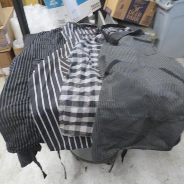 Assorted aprons with various black and gray striped patterns, in good condition, on display in a storage area.