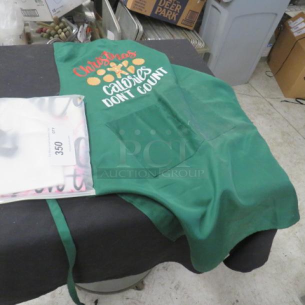 Green apron with "Christmas Calories Don't Count" text, front pockets, in good condition. Includes auction tag 350.