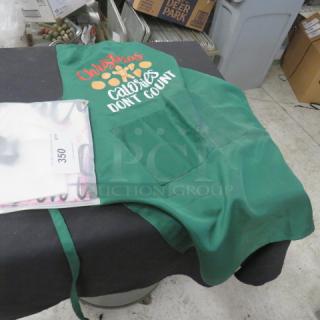 Green apron with "Christmas Calories Don't Count" text, front pockets, in good condition. Includes auction tag 350.