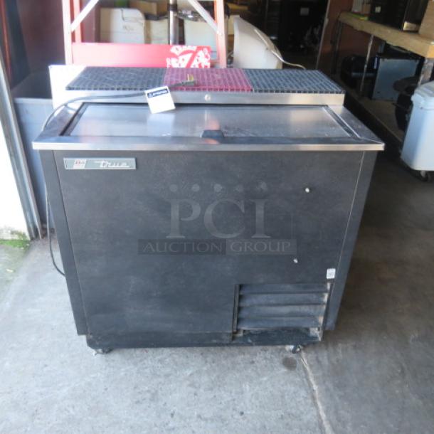 True bottle box cooler on casters, model TD-36-12, 115V, dimensions 37x27x37 inches, black exterior, branded label visible.