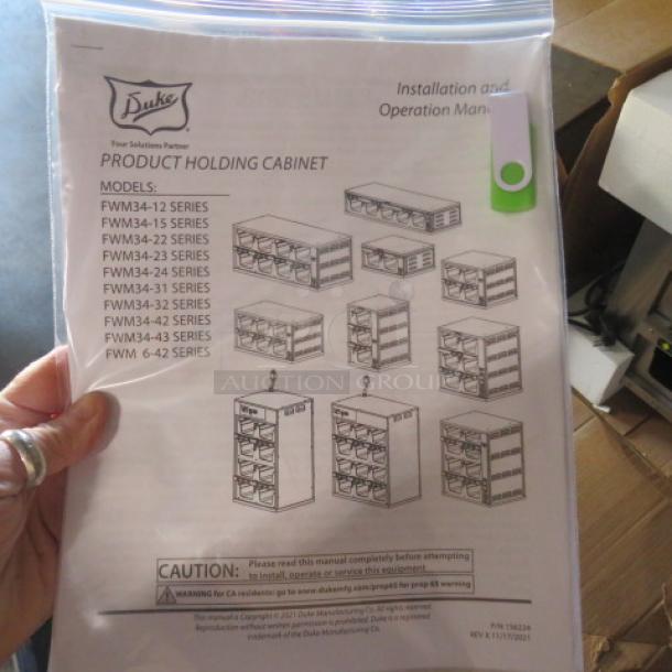 New Duke Product Holding Cabinet, Model FWM34. Installation manual visible, highlighting model series with safety instructions.