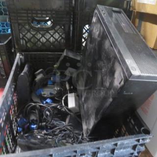 One Lot Of Assorted Electronics; features include cables, power adapters, and a dusty computer tower in a crate.
