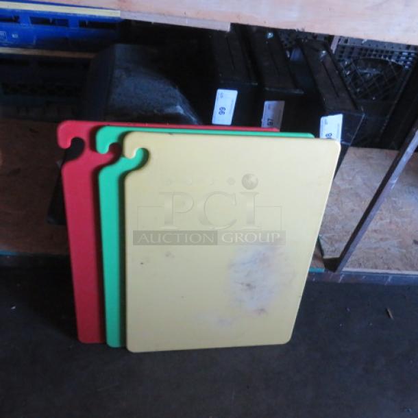 Set of three 24x18 cutting boards in red, green, and yellow with hooks. Signs of wear visible, ideal for kitchen use.