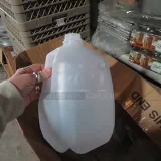 New plastic gallon jug held in hand, part of a large lot. Clear, unbranded, ideal for liquid storage.