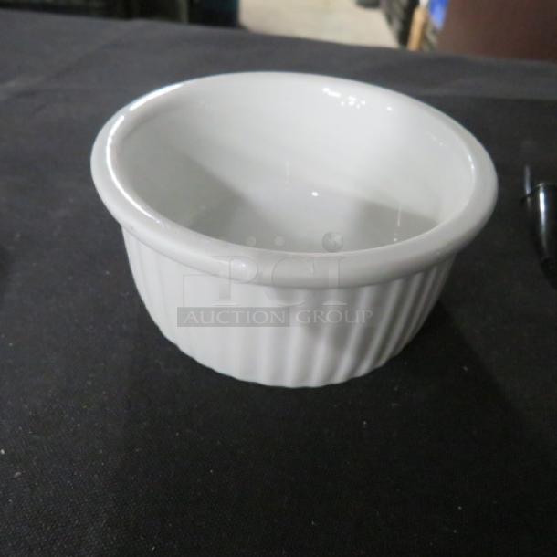 White ceramic ramekin, smooth rim, ribbed exterior, excellent condition. Part of a lot of 23 available for auction.