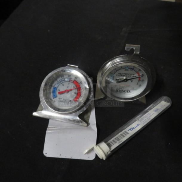 Assorted thermometers, including two metal dial thermometers and one in tube, featuring temperature range markings.