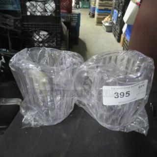 New clear plastic pitchers, set of two, in protective packaging, with auction label showing item number 395, quantity 2.