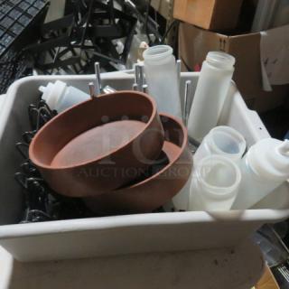 A lot of miscellaneous kitchen items including round brown bowls, plastic condiment squeeze bottles, and metal utensils in a bin.