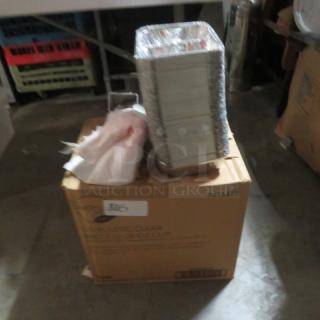 A cardboard box labeled "One Lot Of Paper Products" with a stack of paper trays and plastic wrap on top. Box shows minor wear.