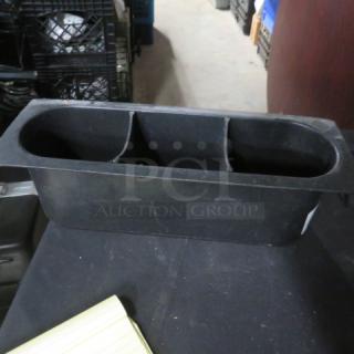 Black plastic bottle holder with two compartments, in used condition, suitable for organizing or storage.