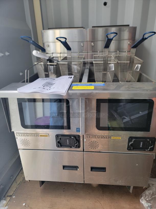 Brand new Pitco Ultrafryer UG14 dual-vat fryer with touchscreen, self-filtering system, baskets, manuals, and factory tags.