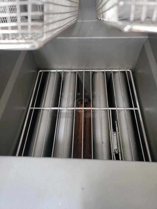 Brand new Pitco Ultrafryer UG14 dual vat fryer interior with heating elements and baskets, showing protective film and inspection tags.