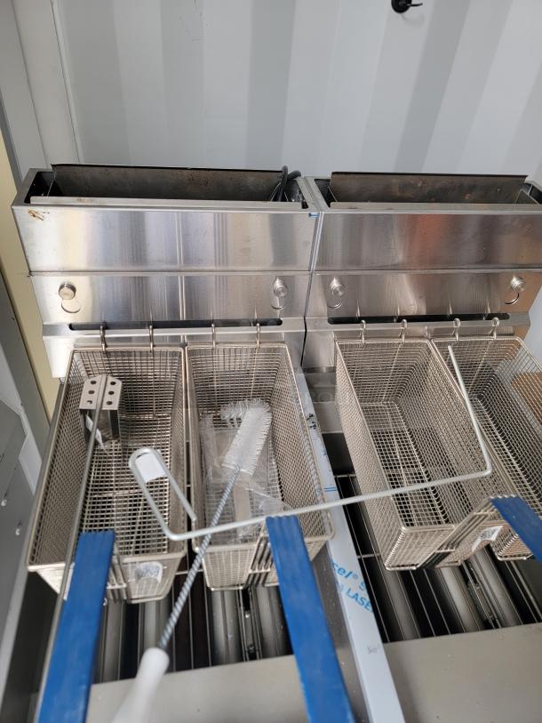 Brand new Pitco Ultrafryer UG14 dual vat fryer with baskets, brushes, and manuals. Protective film and inspection tags intact.