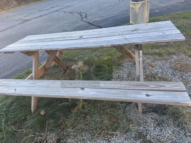 6-foot wooden A-frame picnic table with natural patina, sturdy design, ideal for gatherings, easily refinished.