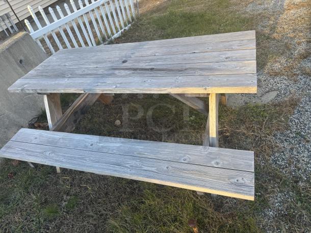 6-foot wooden picnic table with A-frame design, natural patina, sturdy build, ideal for gatherings. Sand/stain to refresh.