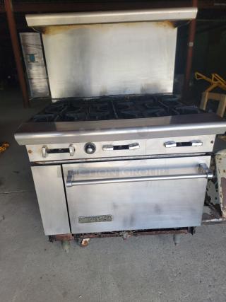 American Range 36" 6-burner gas range, used, with standard oven. Includes bonus ventilation parts. Visible wear and tear.