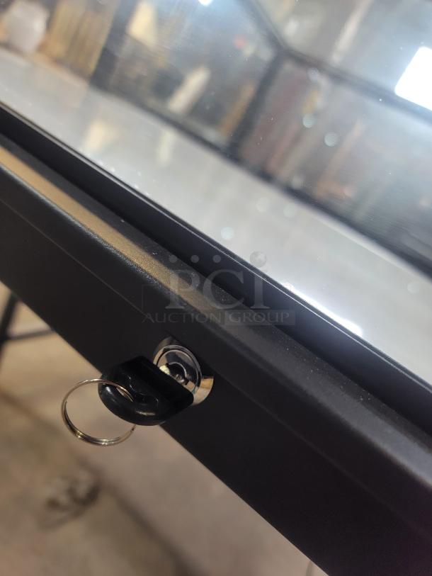 Dawson Jones lighted showcase with secure locking system, black frame, and key visible in lock. Ideal for retail displays.
