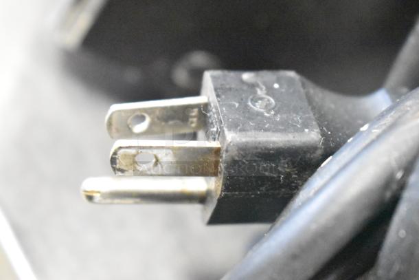 Close-up image of a power cord with a three-prong plug, likely for a Bunn LCA-1 coffee dispenser. Plug shows signs of use.