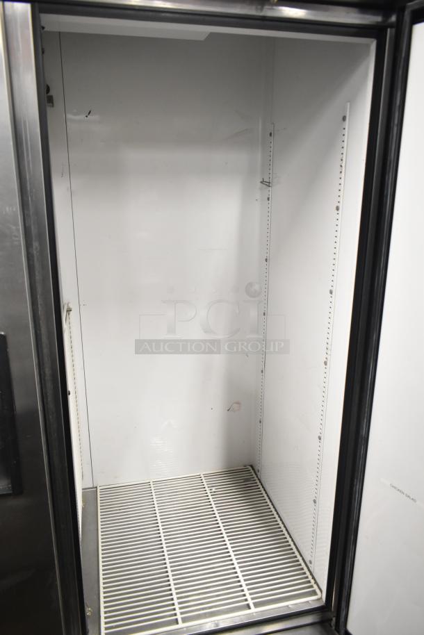 True T-49 Commercial 2 Door Reach In Cooler, 115V, 1 Phase, spacious interior, visible shelving brackets, good condition.