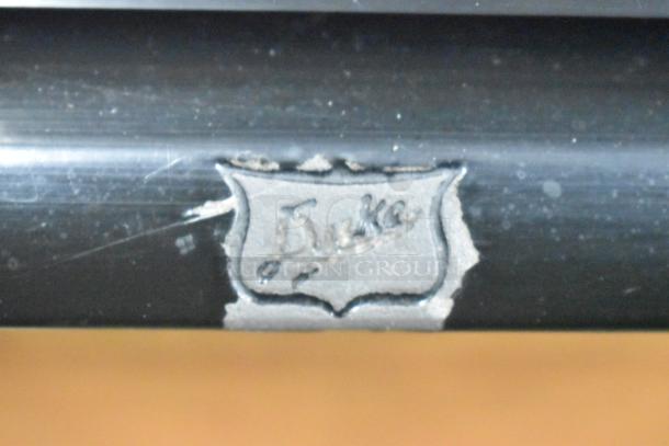 Duke RBC-60 M cooler label, showing brand name in worn, etched metal.