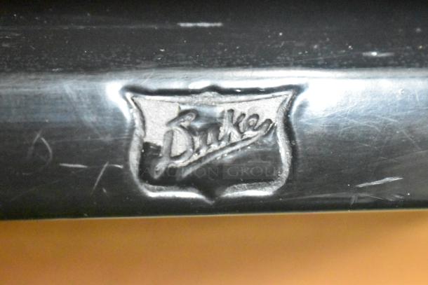 Duke RBC-60 M Commercial Cooler logo detail, showing embossed "Duke" text on metallic surface.