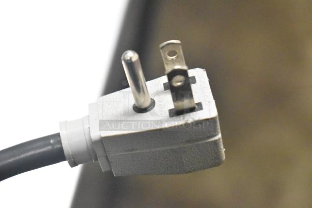 Close-up image of a white electrical plug for the True TSD-09G-HC-LD cooler, showing a three-prong connector.